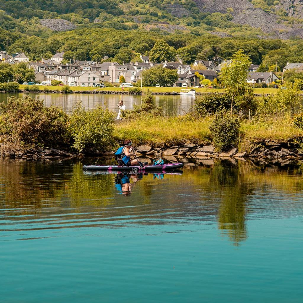 Parc Padarn | Woman sitting down on a paddleboard
